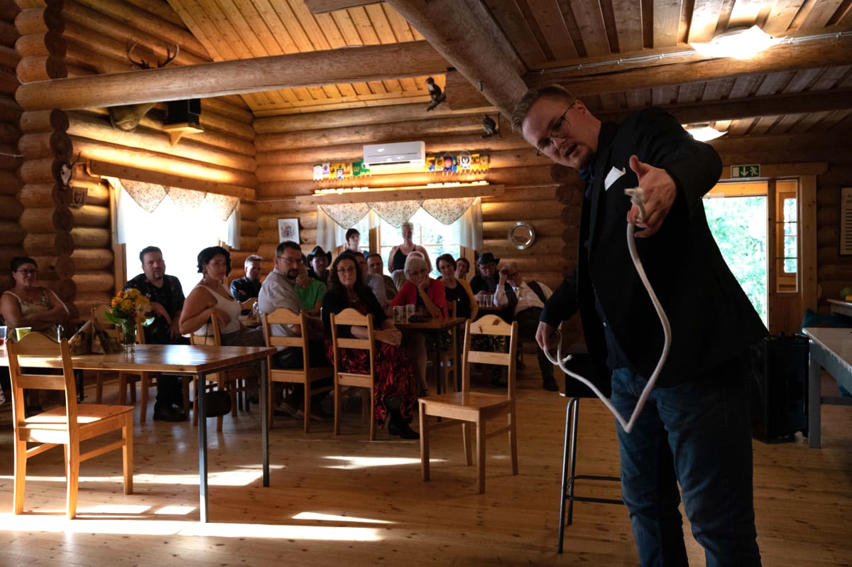 Taavi Saarva performs a rope routine in a party hall as the audience watches from their tables.
