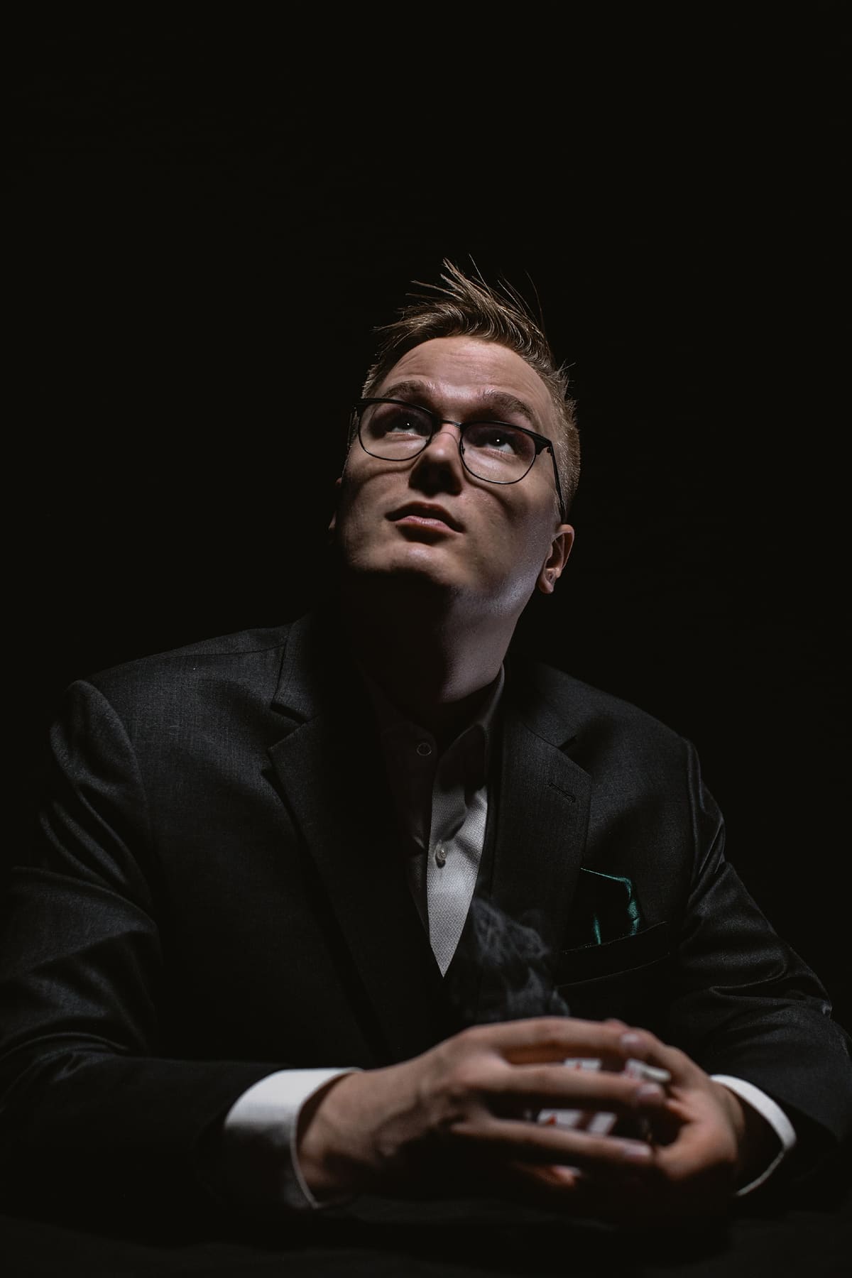 Taavi Saarva sits in a dark suit, looking upwards with his hands clasped on a table.